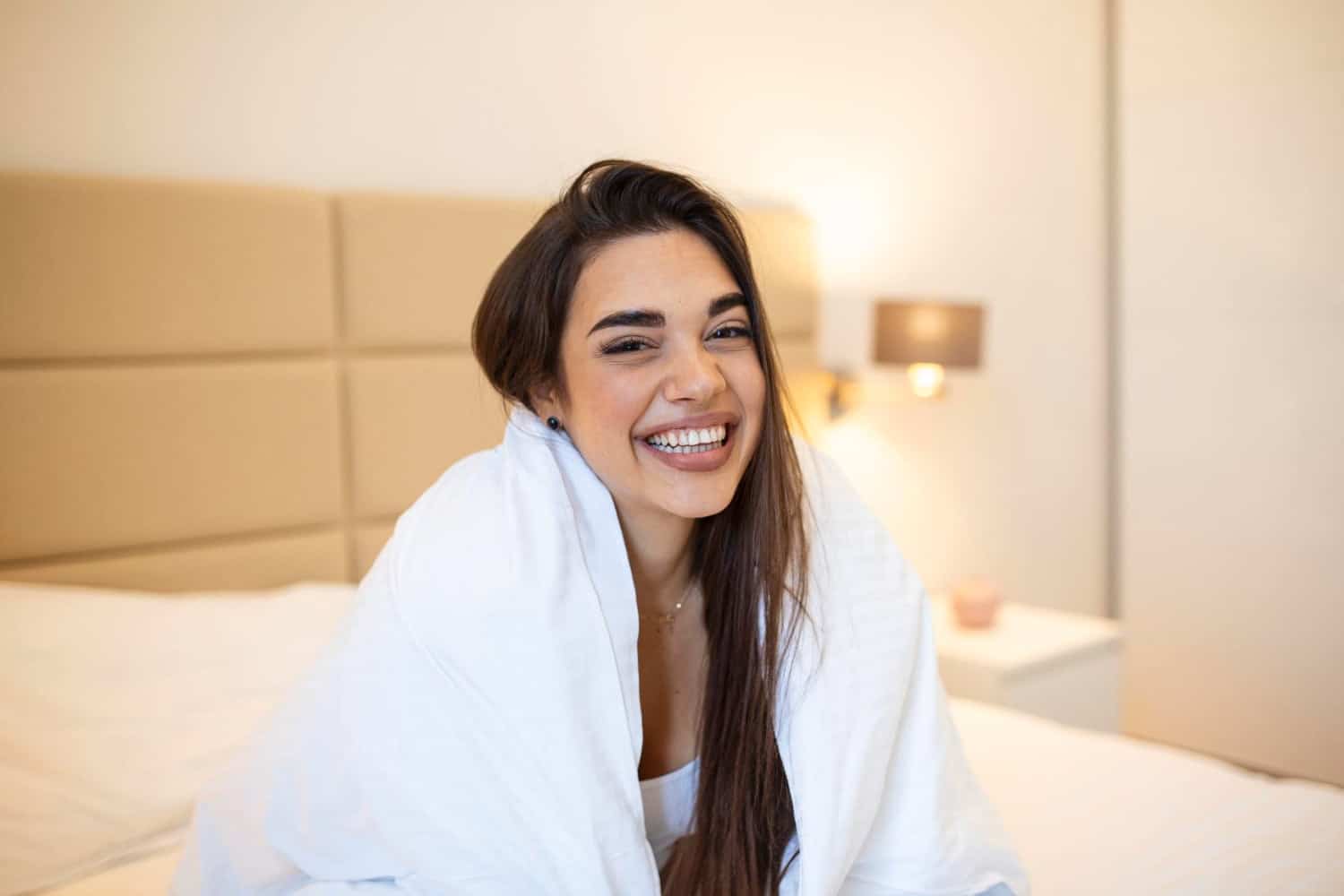 Zirkonyum 4 express tenderness cute young woman keeping smile her face while looking away wrapped white blanket